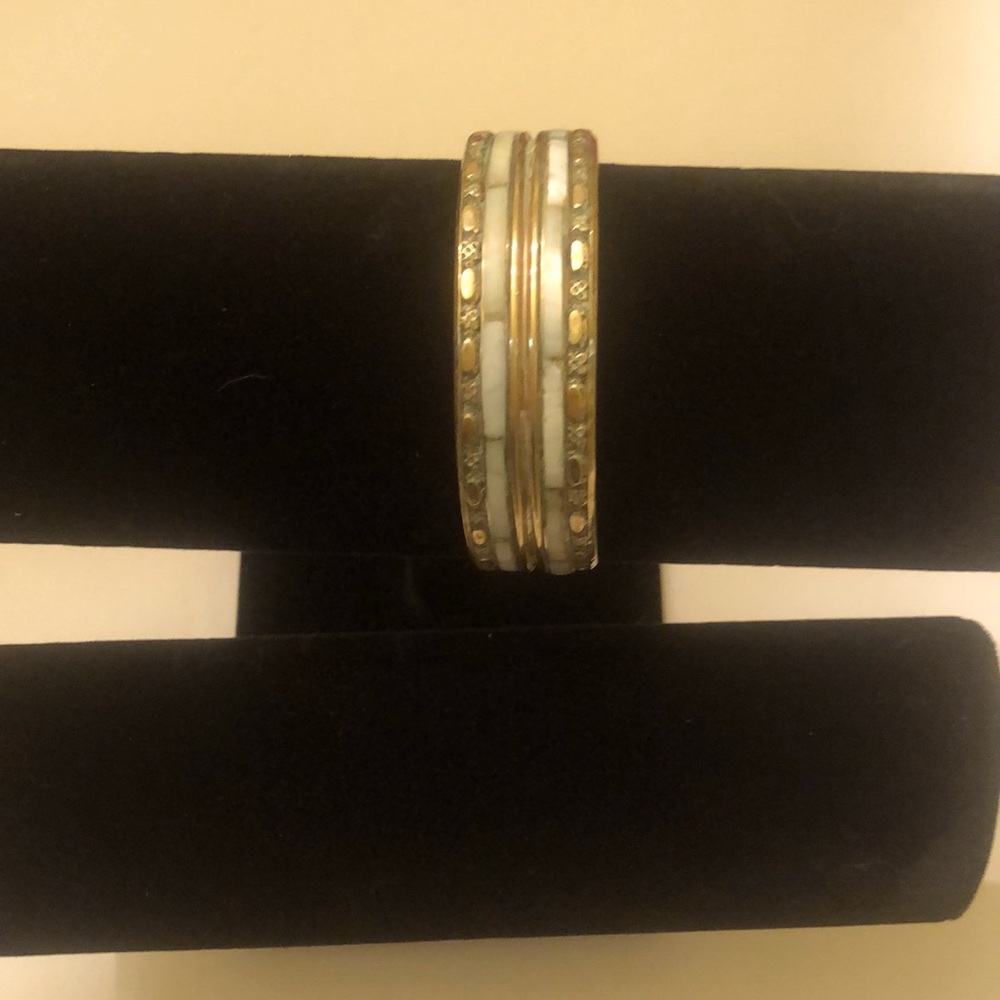 Vintage brass bracelet with mother of pearl inlay and flower and oval border.
